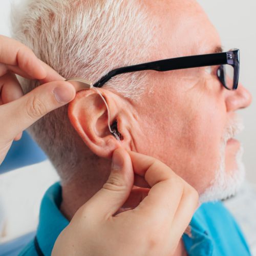 Man having hearing aids fitted
