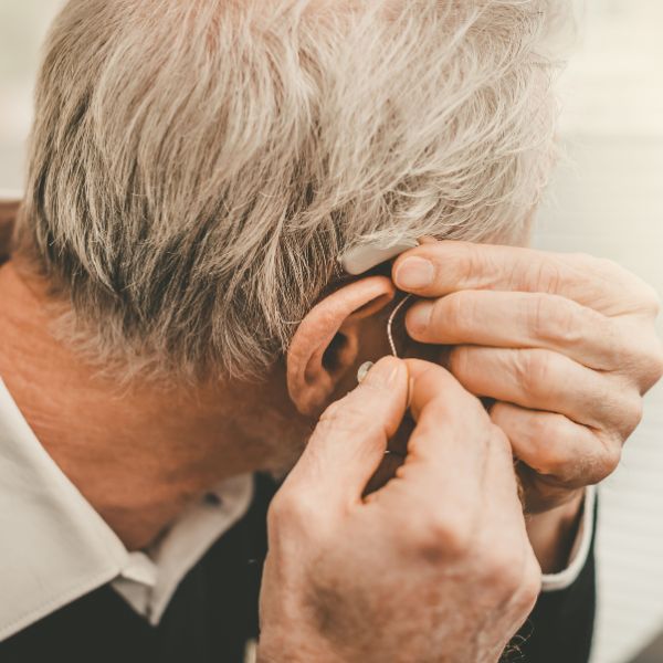 Man putting a hearing aid in