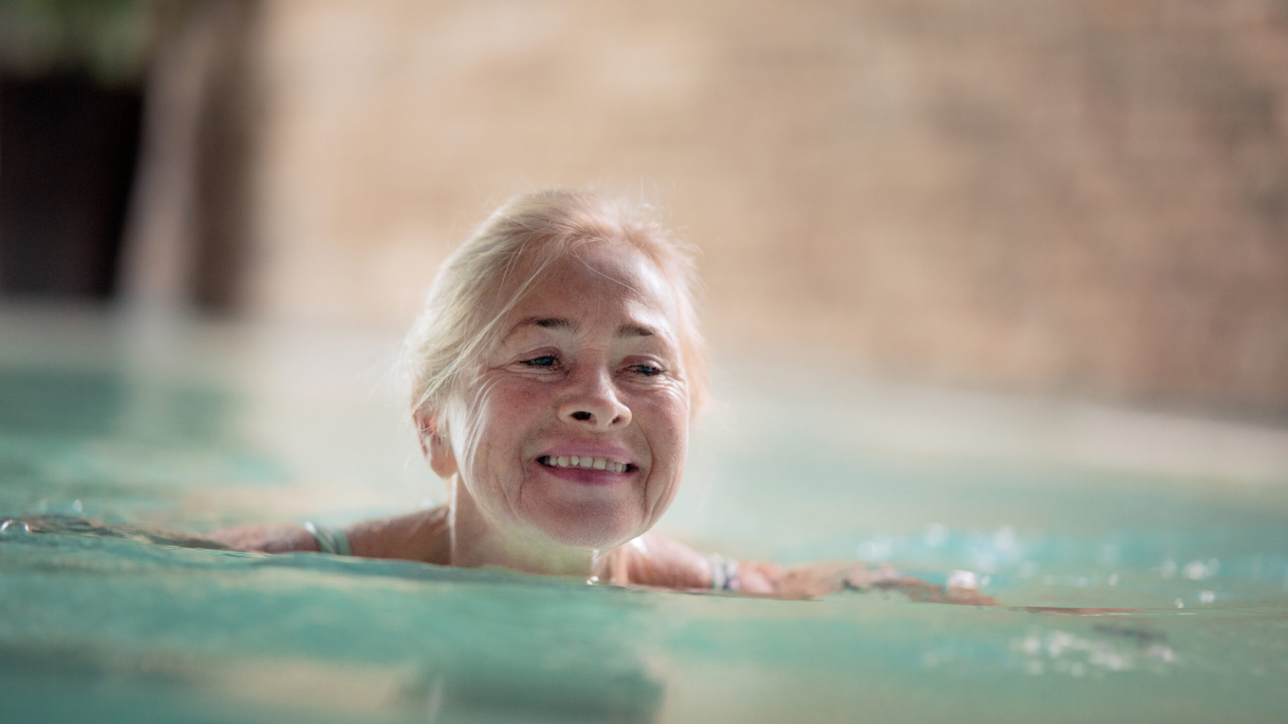 Older woman swimming in an indoor pool