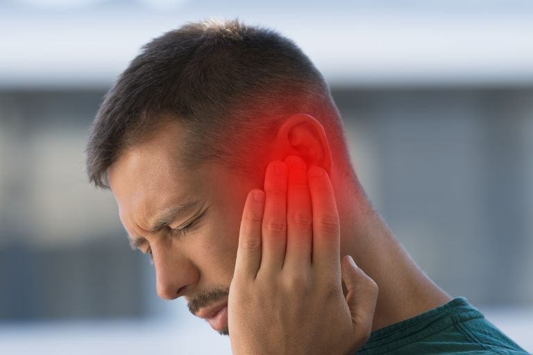 man holding ear in pain